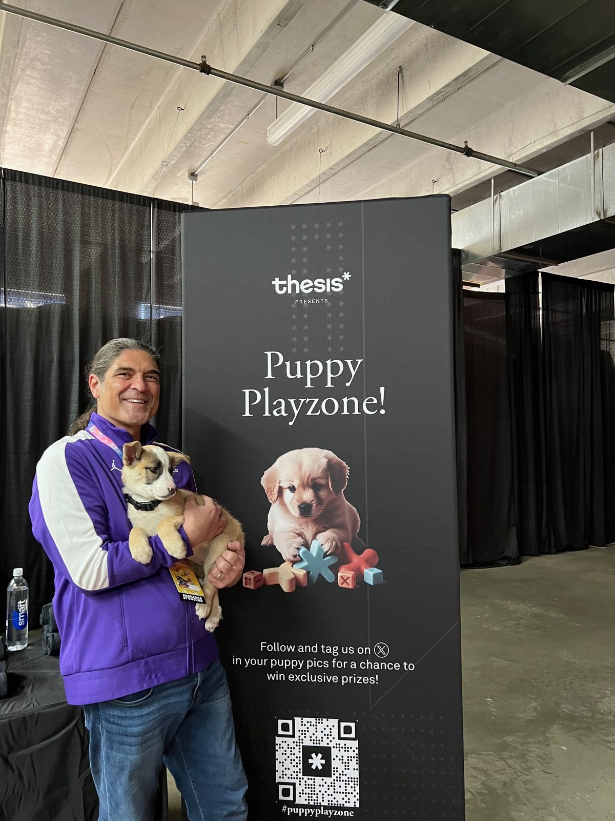 Nico at the Thesis booth holding a puppy